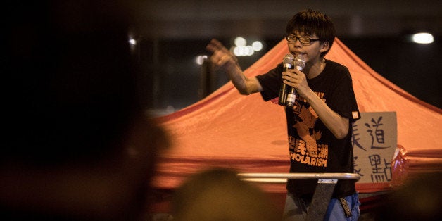 HONG KONG - OCTOBER 01: 17 year-old student protest leader Joshua Wong speaks to fellow students on the street outside the Hong Kong Government Complex on October 1, 2014 in Hong Kong, Hong Kong. Thousands of pro democracy supporters continue to occupy the streets surrounding Hong Kong's Financial district. Protest leaders have set an October 1st deadline for their demands to be met and are calling for open elections and the resignation of Hong Kong's Chief Executive Leung Chun-ying. (Photo by Chris McGrath/Getty Images)