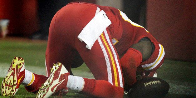 In this Sept. 29, 2014, photo, Kansas City Chiefs free safety Husain Abdullah prays after intercepting a pass and running it back for a touchdown during the fourth quarter of an NFL football game against the New England Patriots Monday, Sept. 29, 2014, in Kansas City, Mo. The NFL said Tuesday, Sept. 30, that Abdullah should not have been penalized for unsportsmanlike conduct when he dropped to his knees in prayer after the interception. (AP Photo/Ed Zurga)