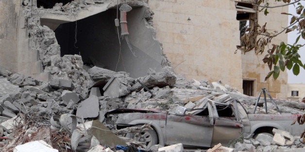 ALEPPO, SYRIA - SEPTEMBER 25: Rubble of destroyed building and a pickup truck, allegedly belonging to Al-Nusra Front, are seen following the U.S.-led coalition's airstrikes against the Islamic State of Iraq and the Levant (ISIL) on a residential area in northern Aleppo, Syria on September 25, 2014. (Photo by Ahmed Hasan Ubeyd/Anadolu Agency/Getty Images)