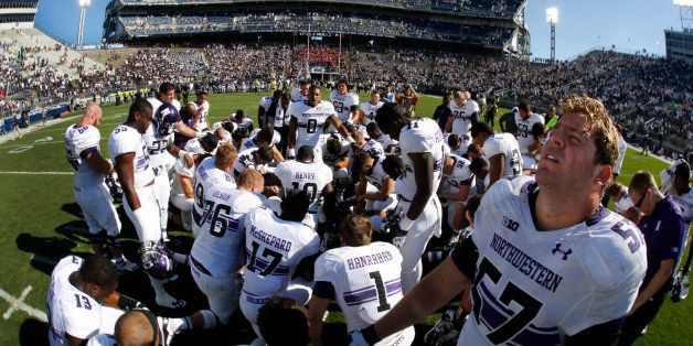 Northwestern offensive linesman Matt Frazier (57) stands as he joins a team prayer on the field at Beaver Stadium after a 29-6 win over Penn State in an NCAA college football game in State College, Pa., Saturday, Sept. 27, 2014. (AP Photo/Gene J. Puskar)