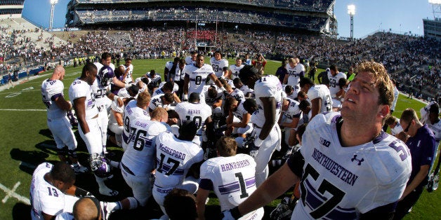 Northwestern offensive linesman Matt Frazier (57) stands as he joins a team prayer on the field at Beaver Stadium after a 29-