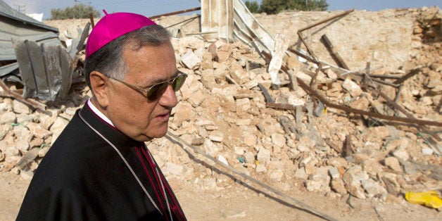 Latin Patriarch of Jerusalem Fouad Twal looks at the ruins of a Palestinian home, on November 5, 2013, a week after it was demolished by the Israeli authority, in Israeli annexed East Jerusalem. The building which was built prior to 1967 belongs to the Latin (Roman Catholic) Patriarchate, and was let to a Palestinian family. Structures built prior to 1967 are legal and were constructed prior to the annexation by Israel of East Jerusalem during the Six-day War. AFP PHOTO /AHMAD GHARABLI (Photo credit should read AHMAD GHARABLI/AFP/Getty Images)