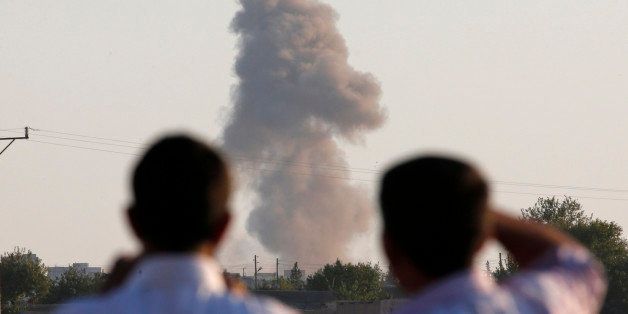 Turkish Kurds standing on the outskirts of Suruc, on the Turkey-Syria border, watch smoke rise following an airstrike in Kobani, Syria, where the fighting between militants of the Islamic State group and Kurdish forces intensified, Tuesday, Oct. 7, 2014. Kobani, also known as Ayn Arab and its surrounding areas have been under attack since mid-September, with militants capturing dozens of nearby Kurdish villages. (AP Photo/Lefteris Pitarakis)