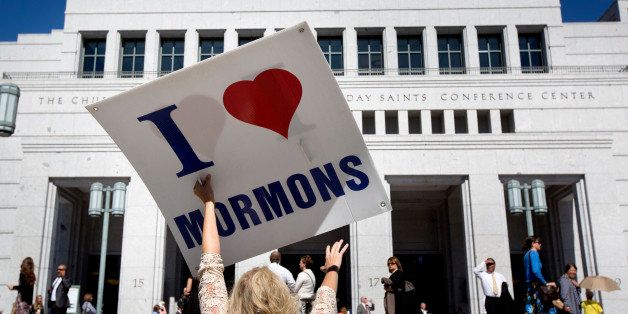 A women stands between anti-Mormon protesters and conference attendees as people arrive for the afternoon session of the two-day Mormon church conference Saturday, Oct. 4, 2014, in Salt Lake City. Leaders of The Church of Jesus Christ of Latter-day Saints made announcements about church statistics, new temples or initiatives. (AP Photo/Kim Raff)