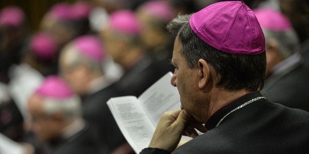 A Bishop lookwatches as Pope Francis delivers his speech during the Synod on the Families, to cardinals and bishops gathering in the Synod Aula, at the Vatican, on October 6, 2014. Pontiff on Sunday launched a major review of Catholic teaching on the family that could lead to change in the Church's attitude to marriage, cohabitation and divorce. An extraordinary synod, or meeting, of nearly 200 bishops from around the world and a sprinkling of lay people will, for the next two weeks, address the huge gulf between what the Church currently says on these issues and what tens of millions of believers actually do. AFP PHOTO / ANDREAS SOLARO (Photo credit should read ANDREAS SOLARO/AFP/Getty Images)