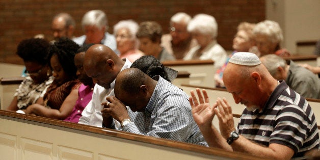 Andy Boyter, right, joins others in prayer at a Wilshire Baptist Church service, Wednesday, Oct. 8, 2014, in Dallas. The service, that attracted nearly 150 attendees, was dedicated to Thomas Eric Duncan who died Wednesday at Texas Health Presbyterian Hospital in Dallas from complications of Ebola. (AP Photo/Tony Gutierrez)