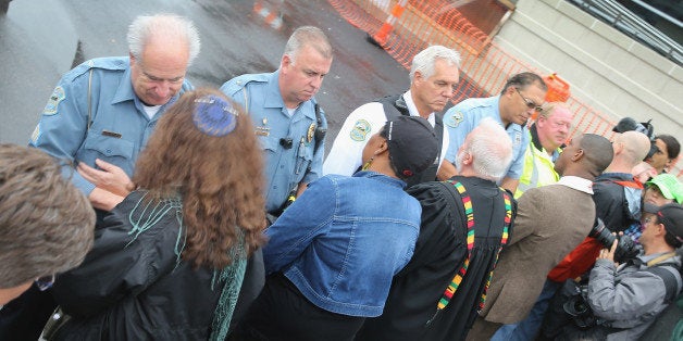 FERGUSON, MO - OCTOBER 13: Members of the clergy pray for police officers during a protest outside the Ferguson police station on October 13, 2014 in Ferguson, Missouri. Ferguson has been struggling to heal since riots erupted following the August 9, killing of 18-year-old Michael Brown by a police officer in suburban Ferguson. Another teenager, Vonderrit Myers Jr., was killed by a St. Louis police officer on October 8. Several demonstrators and members of the clergy were arrested at the protest after a show of civil disobedience. (Photo by Scott Olson/Getty Images)