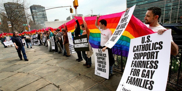 Richard Ferrara, right, of New York, holds a sign and the rainbow flag along with others during a Dignity USA demonstration Saturday, April 12, 2008 in New York, NY. Dignity USA, a Catholic gay rights group, held the demonstration across the street from the United Nations complex ahead of Pope Benedict XVI's upcoming visit to the U.S. next week. (AP Photo/Craig Ruttle)