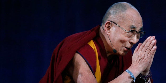 The Dalai Lama bids the audience goodbye at the Massachusetts Institute of Technology in Cambridge, Mass., Friday, Oct. 31, 2014, after participating in a panel discussion with professors and young students. (AP Photo/Elise Amendola)