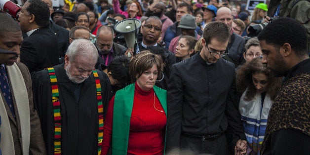 FERGUSON, MO - OCTOBER 13: Clergy members lead hundreds of protestors march from Wellspring Church to the Ferguson police station in an act of civil disobedience on October 13, 2014 in Ferguson, Missouri. The protests are part of four days of planned action that organizers have called 'Ferguson October' following the shooting death of unarmed black teen Michael Brown, 18, by white police officer Darren Wilson in the St. Louis suburb of Ferguson on August 9. The shooting death of another 18-year-old Vonderrit Myers by an off-duty St. Louis police officer on October 8 has sparked a new round of protests. (Photo by Samuel Corum/Anadolu Agency/Getty Images)