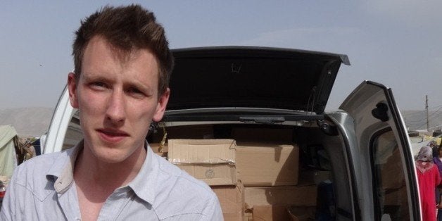 FILE - In this undated file photo provided by his family, Peter Kassig stands in front of a truck filled with supplies for Syrian refugees. The Indianapolis, Indiana, aid worker being held by the Islamic State group told family and teachers that heâd found his calling in 2012 when he decided to stay in the Middle East instead of returning to college, according to an email released Tuesday, Oct. 14, 2014 by his family. (AP Photo/Courtesy Kassig Family, File)