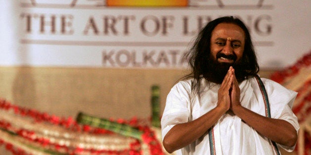 Indian spiritual guru and founder of The Art of Living Foundation Sri Sri Ravi Shankar greets followers as he arrives at a meditation camp in Calcutta, India, Saturday, Feb. 14, 2009. (AP Photo/Bikas Das)