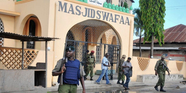 In this photo taken Wednesday, Nov. 19, 2014, armed police walk out of the Masjid Swafaa mosque after raiding it, in Mombasa, Kenya. Methods used by Kenyan authorities to tackle extremism on the country's coast will increase support for radicals, a human rights official warned Friday, Nov. 21, 2014, after authorities raided and closed four mosques over the last week, in which the police said they recovered grenades and a gun but some muslims allege were planted in order to justify the mosques' closures. (AP Photo)