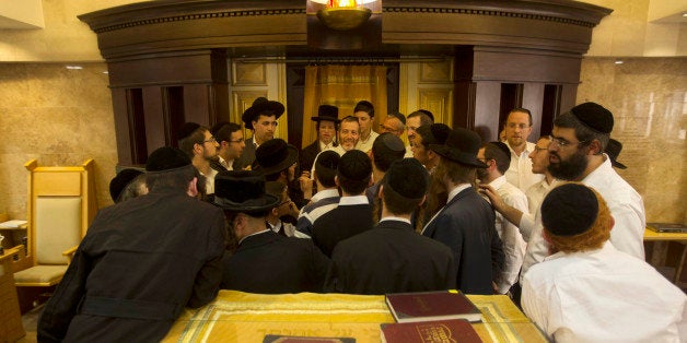 Ultra-Orthodox Jewish men gather around Yosef Posternac, center as he tells his account a day after a shooting attack at the synagogue in Jerusalem, Wednesday, Nov. 19, 2014. The synagogue attack, which left five people dead, was the deadliest in Jerusalem since 2008 and came amid weeks of violence linked to a disputed holy site sacred to Jews and Muslims. Nearly a dozen people have been killed in attacks by Palestinians using guns, knives and vehicles. (AP Photo/Sebastian Scheiner)