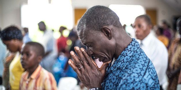 MONROVIA, LIBERIA - OCTOBER 12: A Christian prays for the people who died due to Ebola, on a ritual in St. Joseph Parish Catholic Church in Monrovia, Liberia on 12 October, 2014. (Photo by Mohammed Elshamy/Anadolu Agency/Getty Images)