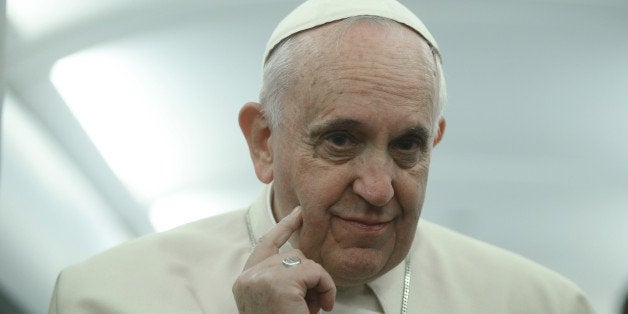 Pope Francis touches his face during a press conference aboard the flight towards Rome, Sunday, Nov. 30, 2014. Francis kicked off his final day in Turkey with a lengthy, two-hour liturgy alongside Ecumenical Patriarch Bartholomew I in the Orthodox Church of St. George, where incense mingled with hypnotic chants and prayers on an important feast day for the Orthodox Church. (AP Photo/Filippo Monteforte, pool)