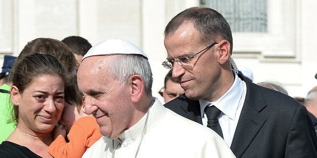 The Commandant of the Pontifical Swiss Guard, Daniel Rudolf Anrig (R) stands behind Pope Francis during a general audience at St Peter's square on October 23, 2013 at the Vatican. Pope Francis dismissed the commander of the Swiss Guard in charge of supervising the Vatican security for being too authoritarian and rigid, said on December 3, 2014 the Italian press. AFP PHOTO / VINCENZO PINTO (Photo credit should read VINCENZO PINTO/AFP/Getty Images)