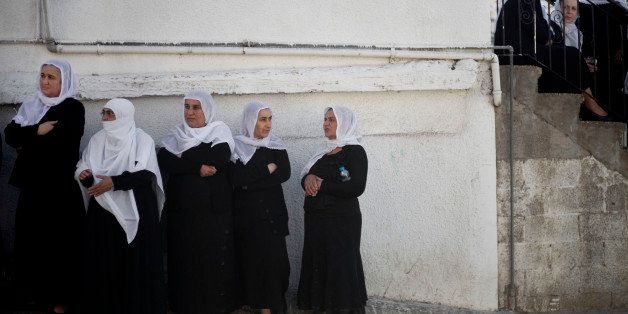 Druze women watch the funeral procession of Israeli Chief Inspector Border Police officer Jaddan Assad in the Druse village of Beit Jann on Mt. Meron in the Galilee, northern Israel, Thursday, Nov. 6, 2014. The officer was killed by a Hamas militant who slammed a minivan into a crowd waiting for a train in Jerusalem, killing one person and wounding at least a dozen before being shot dead by police. (AP Photo/Ariel Schalit)