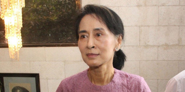 Myanmar Opposition Leader Aung San Suu Kyi arrives for a ceremony to mark one month anniversary of the death of Win Tin, a se