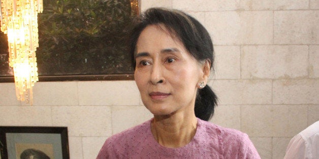 Myanmar Opposition Leader Aung San Suu Kyi arrives for a ceremony to mark one month anniversary of the death of Win Tin, a senior leader of her National League for Democracy (NLD) party, Tuesday, May. 20, 2014, in Yangon, Myanmar. The co-founder of Suu Kyiâs party and prominent journalist who became Myanmarâs longest-serving political prisoner after challenging military rule, died at the age of 85 last month. (AP Photo/Khin Maung Win)