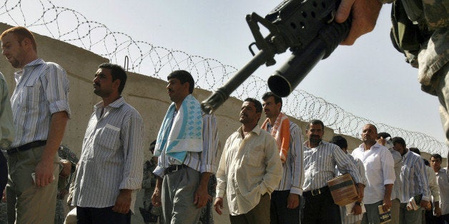 Some of the 200 Iraqi prisoners wait inside the Abu Ghraib prison compound, shortly before they are released from Abu Ghraib prison Thursday June 15, 2006, under a national reconciliation plan announced by Prime Minister Nouri al-Maliki last week, in Baghdad, Iraq. Under the plan, 2,500 inmates will be released. (AP Photo/Ali Jasim, Pool)