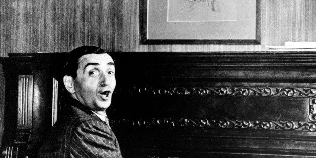 Songwriter Irving Berlin is shown at the keyboards of an upright piano in the 1920s. The portrait on the wall is of George M. Cohan. (AP Photo)