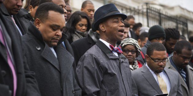 UNITED STATES - DECEMBER 11: Senate Chaplain Barry Black reads a prayer before staging a 'hands up' protest on the House steps of the Capitol, December 11, 2014. The event was attended by mostly black congressional staffers to protest the grand jury decisions in the Michael Brown and Eric Garner police shootings. (Photo By Tom Williams/CQ Roll Call)
