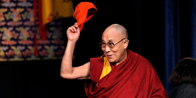 CORRECTS SPELLING OF DALAI LAMA - The Dalai Lama waves a Princeton University cap as he greets a gathering at Princeton University Tuesday, Oct. 28, 2014, in Princeton, N.J. (AP Photo/Mel Evans)