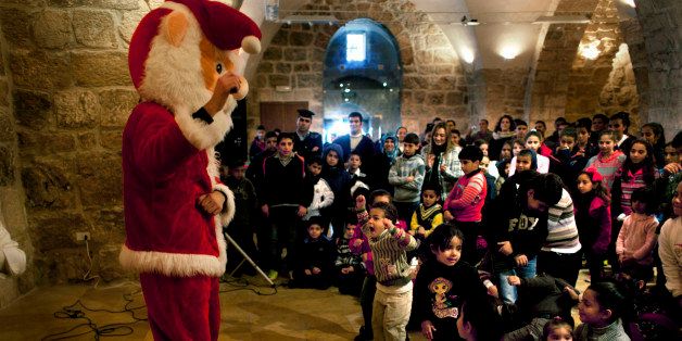 Children sing and dance during an entertainment program for visiting Christian families at the Church of the Nativity, traditionally believed by Christians to be the birthplace of Jesus Christ, in the West Bank city of Bethlehem, Sunday, Dec. 22, 2013. Christians around the world will celebrate Christmas this week. (AP Photo/Nasser Nasser)