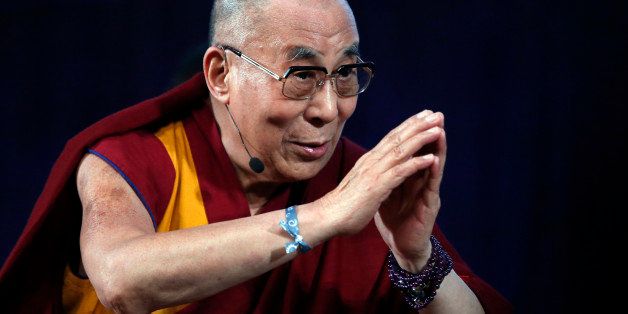 The Dalai Lama bids the audience goodbye at the Massachusetts Institute of Technology in Cambridge, Mass., Friday, Oct. 31, 2014 after participating in a panel discussion with professors and young students. (AP Photo/Elise Amendola)