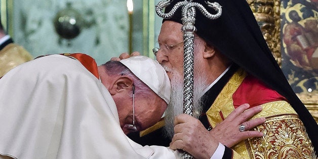 In this photo provided by Vatican newspaper L'Osservatore Romano, Ecumenical Patriarch Bartholomew I, right, kisses Pope Francis' head during an ecumenical prayer at the Patriarchal Church of St. George in Istanbul, Saturday, Nov. 29, 2014. The two major branches of Christianity represented by Bartholomew and Francis split in 1054 over differences on the power of the papacy. The two spiritual heads will participate in an ecumenical liturgy and sign a joint declaration in the ongoing attempt to reunite the churches. (AP Photo/L'Osservatore Romano, ho)