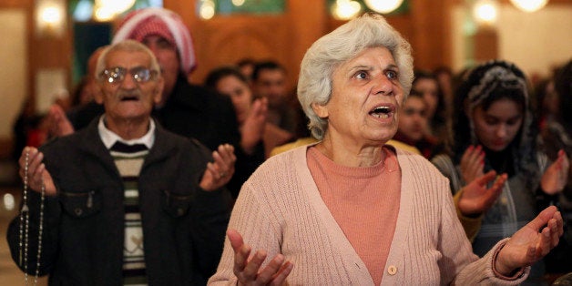 Iraqi Christians attend a Christmas Eve mass at Our Lady of Salvation in Baghdad, Iraq, Wednesday, Dec. 24, 2014. Iraqi Christians gathered for Christmas Eve services amid tight security. (AP Photo/Hadi Mizban)