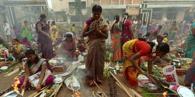 An Indian Hindu devotee prays during the community function on the occasion of Pongal in Mumbai on January 14, 2014. Pongal is a thanksgiving or harvest festival celebrated by people hailing from the Indian state of Tamil Nadu. Pongal coincides with the Hindu festival Makara Sankranthi and is celebrated throughout India as the winter harvest. AFP PHOTO/ PUNIT PARANJPE (Photo credit should read PUNIT PARANJPE/AFP/Getty Images)