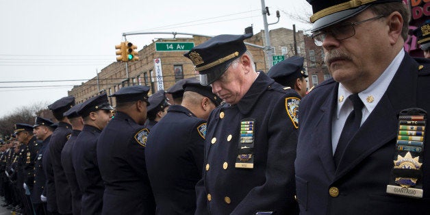 Some police officers turn their backs as Mayor Bill de Blasio speaks during the funeral of New York Police Department Officer Wenjian Liu at Aievoli Funeral Home, Sunday, Jan. 4, 2015, in the Brooklyn borough of New York. Liu and his partner, officer Rafael Ramos, were killed Dec. 20 as they sat in their patrol car on a Brooklyn street. The shooter, Ismaaiyl Brinsley, later killed himself. (AP Photo/John Minchillo)