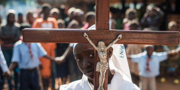 A girl carrying a cross arrives to celebrate mass at Saint Charles Lwanga church in Bangui on December 15, 2013. The Central African Republic's president offered yesterday to hold talks with Christian militia groups in efforts to end spiralling sectarian violence that has killed hundreds of people in a week.AFP PHOTO / FRED DUFOUR (Photo credit should read FRED DUFOUR/AFP/Getty Images)