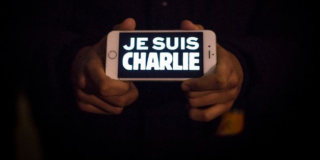 LONDON, ENGLAND - JANUARY 07: A man holds a phone displaying 'Je suis Charlie' (I am Charlie) during a vigil in Trafalgar Square for victims of the terrorist attack in Paris on January 7, 2015 in London, United Kingdom. Twelve people were killed including two police officers as two gunmen opened fire at the offices of the French satirical publication Charlie Hebdo. (Photo by Rob Stothard/Getty Images)