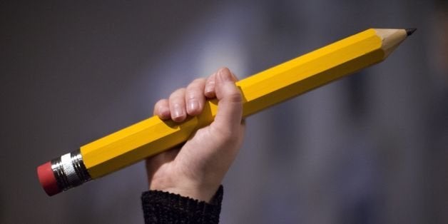 A giant pencil is held up at a vigil outside The French Institute in London on January 9, 2015 for the 12 victims of the atta