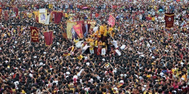 Thousands of devotees try to touch the religious icon of the Black Nazarene during the annual religious procession in Manila