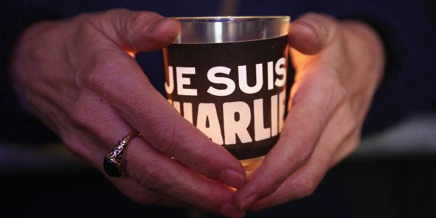 BERLIN, GERMANY - JANUARY 13: People hold candles with 'Je suis Charlie' written on them as they attend a vigil organized by Muslim groups at the Brandenburg Gate to commemorate the victims of the recent terror attacks in Paris on January 13, 2015 in Berlin, Germany. Germany is home to four million Muslims and many mosques and Muslim associations have been outspoken in condemning the recent terror sprees in Paris by Islamic extremists that left 17 people dead, including 10 employees at the satirical Charlie Hebdo magazine. (Photo by Sean Gallup/Getty Images)