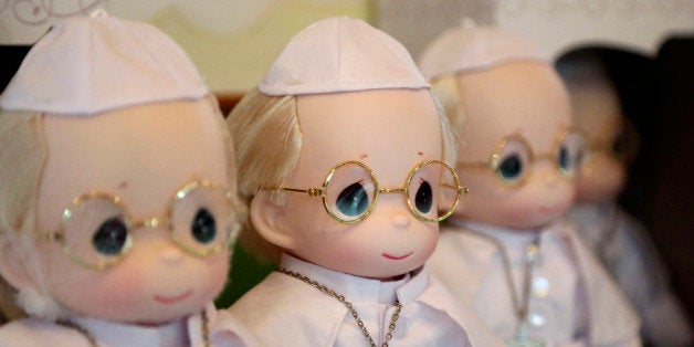 In this Monday Jan. 12, 2015 photo, Pope Francis dolls are on display at a store in Manila, Philippines. The 12-inch limited edition doll costs 1,000 pesos (about US$22) each and comes with a doll box and a certificate of authenticity. Well before Pope Francis' plane touches down in this Asian bastion of the Roman Catholic faith, Filipinos have been snapping their selfies beside his life-sized cutout image in churches and malls. His face beams from welcome posters, shirts, cookies, coins, stamps, coffee mugs and all imaginable mementoes. (AP Photo/Aaron Favila)