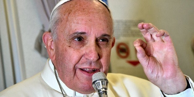 Pope Francis addresses journalist sitting onboard a plane during his trip back to Rome, on January 19, 2015 from the Philippines. The 78-year-old pontiff wrapped up a triumphant visit to the Philippines and Sri Lanka, seeking to promote the Catholic Church in one of its most important growth regions. AFP PHOTO / GIUSEPPE CACACE (Photo credit should read GIUSEPPE CACACE/AFP/Getty Images)