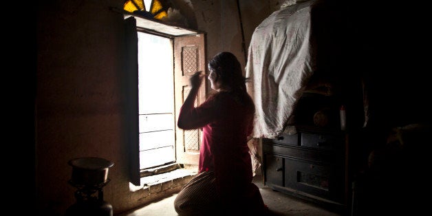 In this Thursday, Jan. 8, 2015 photo, Pakistani Bakhtawar Ijaz, 43, sits in front of the window combing his wig, while prepa