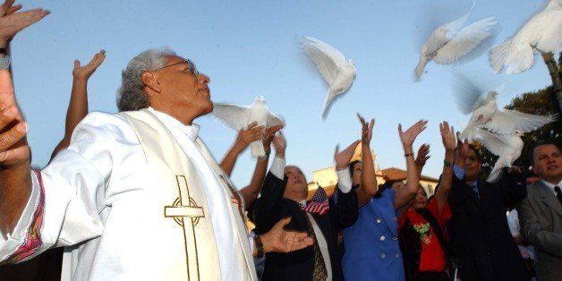 LOS ANGELES, UNITED STATES: US Roman Catholic Father Richard Estrada (L) releases doves 18 September 2001 in Los Angeles, California with immigrant-community leaders as a peace symbol one week after the 11 September terrorist attacks on the US. Four commercial jets carrying 266 people destroyed the World Trade Center, tore into the Pentagon or hit the ground 11 September in an unprecedented attack on the United States. AFP PHOTO/Lucy Nicholson (Photo credit should read LUCY NICHOLSON/AFP/Getty Images)