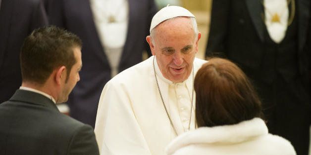 Pope Francis, center, greets newly wed couples during his weekly general audience in the Paul VI hall at the Vatican, Wednesday, Jan. 21, 2015. The pontiff is praising big families after saying Catholics don't have to breed "like rabbits." He says big families are a gift and don't cause poverty in the developing world, and that the real cause of poverty is an unjust economic system that idolizes money over people. (AP Photo/L'Osservatore Romano, Pool)
