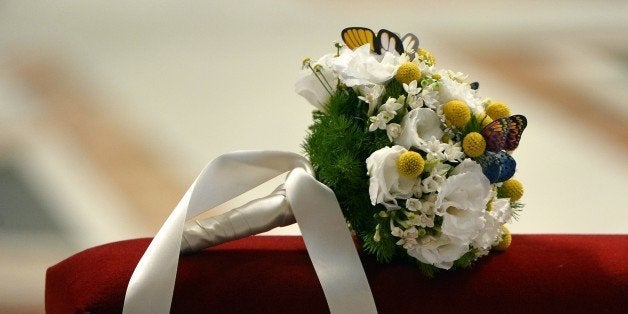 A bridal bouquet lays on a bench during a wedding ceremony celebrated as part of a mass by Pope Francis at St Peter's basilica on September 14, 2014 at the Vatican. AFP PHOTO / ALBERTO PIZZOLI (Photo credit should read ALBERTO PIZZOLI/AFP/Getty Images)