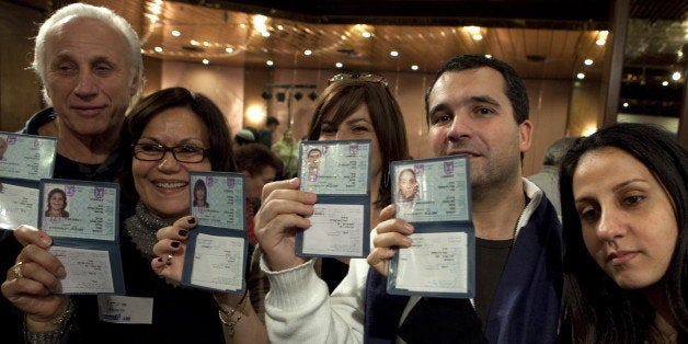 TO GO WITH AFP STORY BY MICHAEL BLUM A group of French Jewish immigrants to Israel show their new Israeli ID cards during a welcoming ceremony organised for them by the Jewish Agency in Jerusalem on December 29, 2009. Between 1968 and 1971, around 15,000 French Jews moved to Israel, but since then smaller numbers have been immigrating into the Jewish state from France. AFP PHOTO/MENAHEM KAHANA (Photo credit should read MENAHEM KAHANA/AFP/Getty Images)