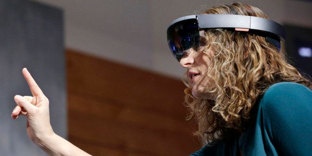 In this Jan. 21, 2015 photo, Microsoft's Lorraine Bardeen demonstrates HoloLens headset during an event at the company's headquarters in Redmond, Wash. With the new HoloLens headset, Microsoft is offering real-world examples to show how you might use three-dimensional digital images _ or holograms _ in daily life. (AP Photo/Elaine Thompson)