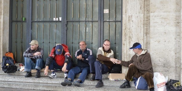 Homeless men chat at the Vatican on November 17, 2014. Pope Francis has ordered the installation of showers for the homeless just next to St Peter's square after a street dweller declared himself too smelly to eat with a bishop. In an initiative sparked by one of his closest aides' encounter with a down-and-out on the streets of Rome, the pontiff has given his blessing to an upgrade of public toilets intended to serve the millions of pilgrims and visitors who flock to the Vatican every year. AFP PHOTO / ANDREAS SOLARO (Photo credit should read ANDREAS SOLARO/AFP/Getty Images)