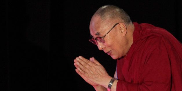 Tibetan spiritual leader the Dalai Lama greets the audience as he arrives to speak on "A Human Approach to World Peace" at Presidency College in Kolkata, India, Tuesday, Jan. 13, 2015. (AP Photo/Bikas Das)