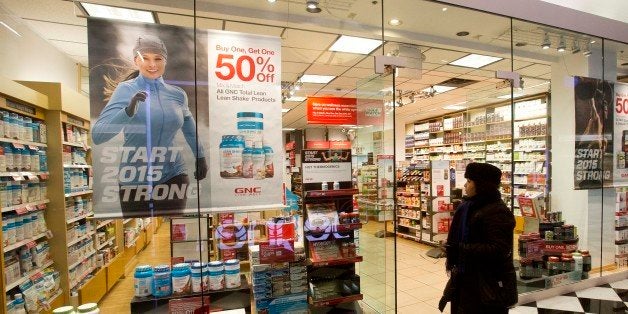 A woman walks past a GNC store, Tuesday, Feb. 3, 2015 in New York. Numerous store brand supplements arenât what their label